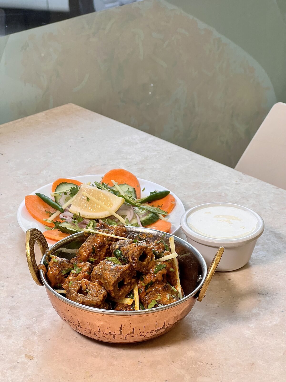 Beef seekh kabab karahi served with fresh salad and raita at Qasar Al Qasimiah